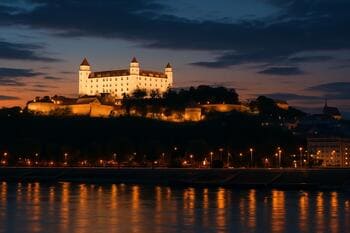 Bratislavský hrad pri súmraku so svetlami mesta pod ním