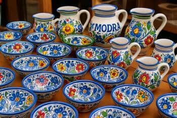 Stôl s modranskými keramickými miskami a džbánmi na trhu