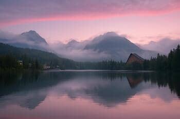 Štrbské pleso pri svitaní s ružovým okrajom oblohy
