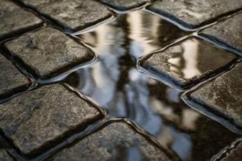 Detail kamennej dlažby s vodou po daždi